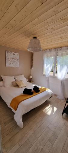 une chambre avec un grand lit avec un plafond en bois dans l'établissement Belle Océane, à Lège