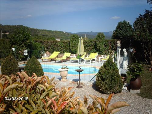 a swimming pool in a garden with chairs and plants at Appartement Locéanaïs in Régusse