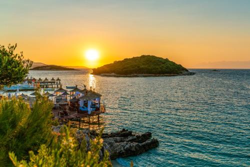 un tramonto su una piccola isola nell'acqua di Olivia Apartment a Sarandë
