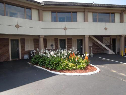 a building with a flower bed in front of it at Knights Inn Bristol in Levittown