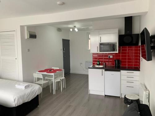 a small kitchen with a bed and a table in a room at Comfortable - Cosy - Budget Studios in City Center in London