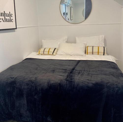 1 dormitorio con 1 cama grande y espejo en la pared en Urban Getaway Apartment Ipswich en Ipswich
