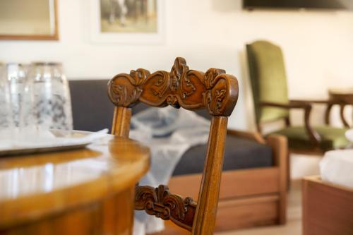 a wooden chair sitting next to a table at Weisses Rössl in Caldaro