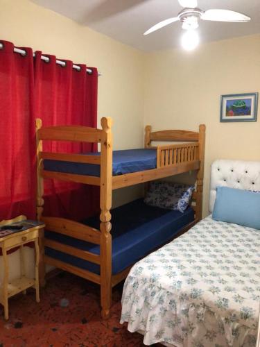 a bedroom with two bunk beds and a bed at Prainha Pousada - Bar e Restaurante in Itanhaém