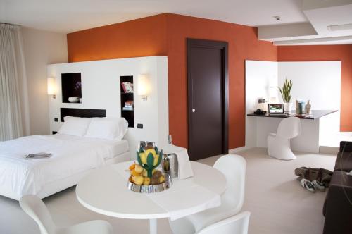 a bedroom with a white bed and a table and chairs at Hotel Du Lac - Relax Attitude Hotel in Brenzone sul Garda