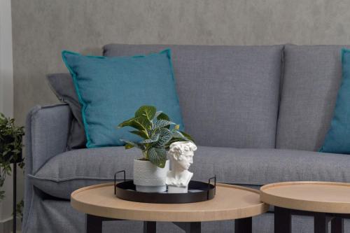 a living room with a couch and a plant on a table at 7Rizes Luxury Living in Heraklio Town