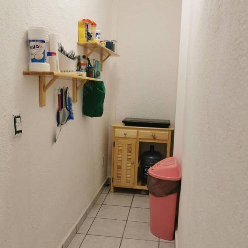 a hallway with a small cabinet in the corner of a room at Lovely studio apartment with balcony AC & wi-fi, minutes from downtown! in Zihuatanejo