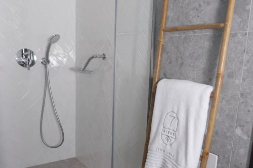 a shower with a white towel on a towel rack at 7Rizes Luxury Living in Heraklio Town