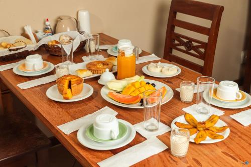 un tavolo di legno con piatti di cibo sopra di Barcaça Pousada a Itacaré