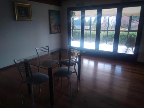 comedor con mesa de cristal y sillas en Chalet Céntrico en Barrio Residencial en San Carlos de Bariloche