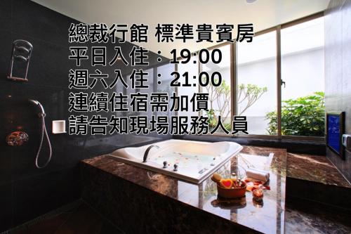 a bathroom with a sink with writing on the wall at 總裁行館Motel in Guishan