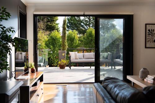a living room with a couch and a sliding glass door at East St Spa House in Daylesford