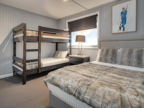 a bedroom with two bunk beds and a lamp at Chalet Alpina in Jindabyne