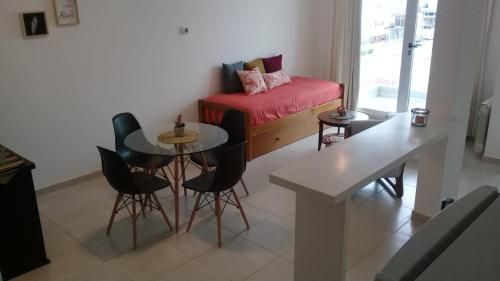 Una sala de estar con una mesa y sillas y un sofá. en Veluvi, en Puerto Madryn