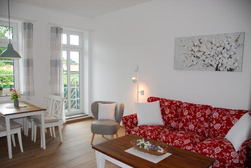 ein Wohnzimmer mit einem roten Sofa und einem Tisch in der Unterkunft Ferienwohnung-Joisten in Kirchgellersen