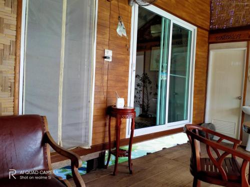 a screened in porch with a window and a chair at Seaside home in Koh Mook