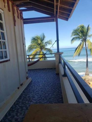 a balcony with a view of the beach and the ocean at Yaeliz Front Beach in Aguada
