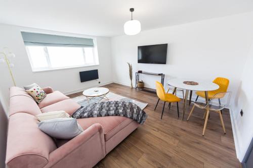 a living room with a couch and a table at Coastline Villas - Heart of Redcar 1 & 2 Bed Apartments, ideal for contractors and holidayers in Redcar
