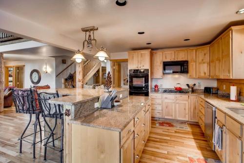 a kitchen with wooden cabinets and granite counter tops at Amazing Private Luxury Home with Stunning Panoramic Views - The Timbers at Glacier Ridge in Fairplay