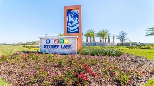 a sign in the middle of a field with flowers at Renewed Luxury Townhouse with private pool in Kissimmee