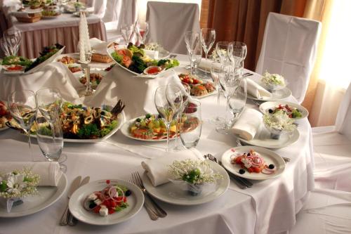 a white table with plates of food on it at Hotel Praha in Uzhhorod
