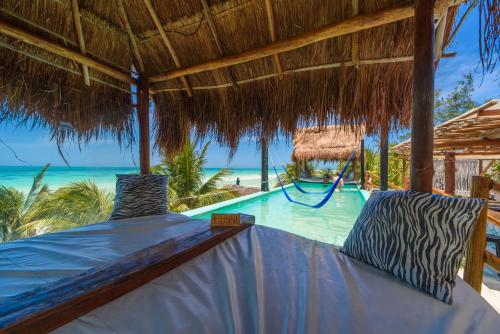 a bed in a resort with a swimming pool at Hotel Villas Tiburon Adults Only in Holbox Island
