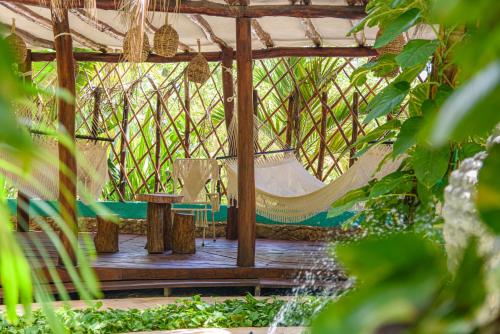 a hammock in a gazebo in a garden at Hotel Villas Tiburon Adults Only in Holbox Island