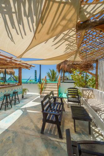 a group of benches sitting under a large umbrella at Hotel Villas Tiburon Adults Only in Holbox Island