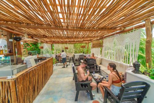 a group of people sitting in chairs under a pergola at Hotel Villas Tiburon Adults Only in Holbox Island