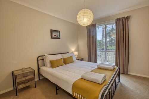 Un dormitorio con una cama grande y una ventana en Front Row Beachfront en Binalong Bay