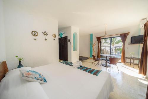 a bedroom with two beds and a dining room at Hotel Villas Tiburon Adults Only in Holbox Island