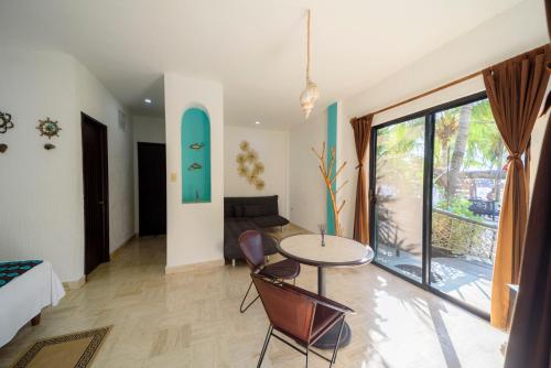 a room with a table and chairs and a couch at Hotel Villas Tiburon Adults Only in Holbox Island
