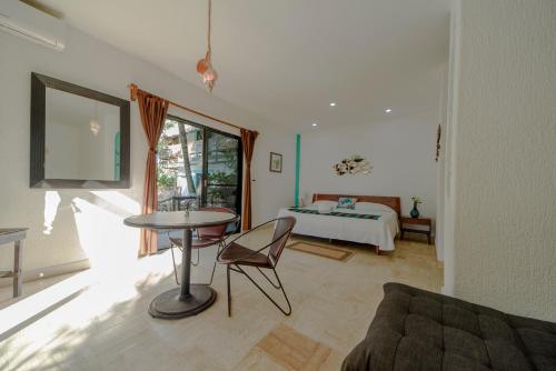 a living room with a bed and a table and a couch at Hotel Villas Tiburon Adults Only in Holbox Island