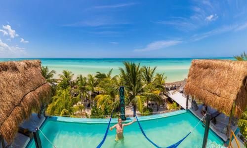 a man in the infinity pool at the beach resort at Hotel Villas Tiburon Adults Only in Holbox Island