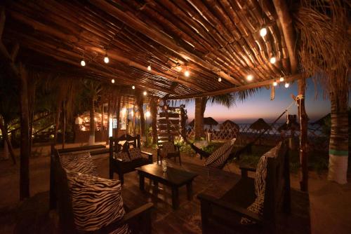 a patio with chairs and a table and lights at Hotel Villas Tiburon Adults Only in Holbox Island