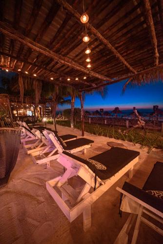 a row of lounge chairs on the beach at night at Hotel Villas Tiburon Adults Only in Holbox Island