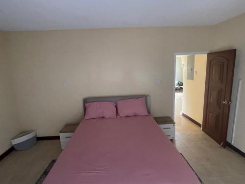 a bedroom with a pink bed with pink pillows at ‘MAYARO’ Private Room with Ocean View in Saint Philip