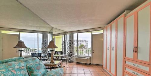 a living room with a blue couch and a table at Absolute Beach - Sea View at Symphony Beach Club! in Ormond Beach
