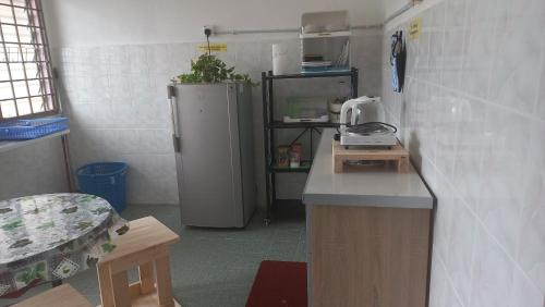 a kitchen with a counter and a refrigerator at BenBahrains Homestay - PB - ISLAMIC COMPLIANCE ONLY in Masjid Tanah