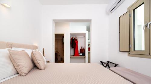 a bedroom with a large bed with white walls at Aerenia Luxury Suites in Karterados
