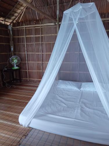 a bed in a room with a mosquito net at Happy Homestay Arborek in Besir