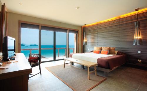 a bedroom with a bed and a view of the ocean at Sri Panwa Phuket Luxury Pool Villa Hotel - SHA Plus in Panwa Beach