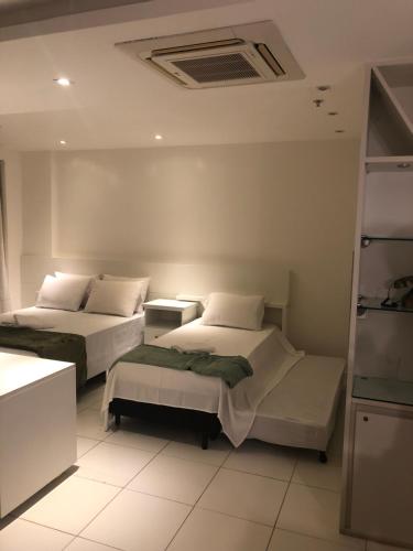 una habitación con dos camas en una habitación en Mandai 01 suíte APT 311 MC temporadas, en Cabo Frío