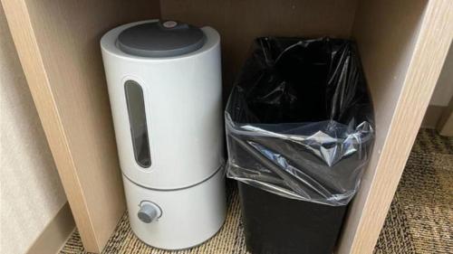 a white and black appliance sitting next to a trash can at Toyoko Inn Gumma Isesaki Ekimae in Isesaki