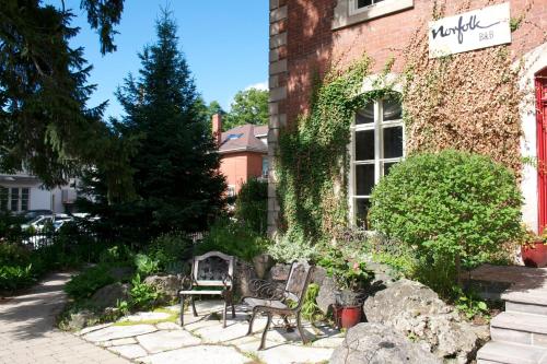 two chairs and a table outside of a building at Norfolk Guest House Inn in Guelph