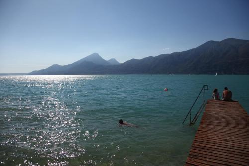a person swimming in the water near a dock at Hotel Rabay in Brenzone sul Garda