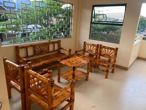 une chambre avec quatre chaises en bois et une table dans l'établissement Lee's Apartment, à Dumaguete