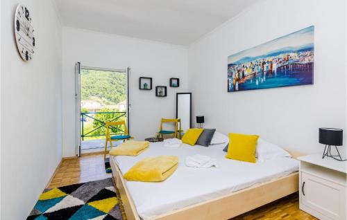 a bedroom with a bed with yellow pillows on it at Nice Home In Broce With House A Panoramic View in Broce