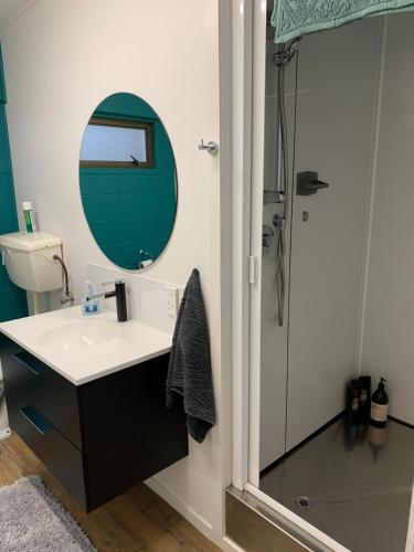 a bathroom with a sink and a shower with a mirror at Suburban Studio in Hamilton