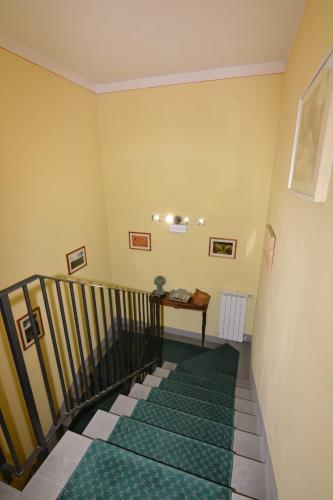 a staircase with a green carpet in a room at Albergo Casa Al Sole in Greve in Chianti